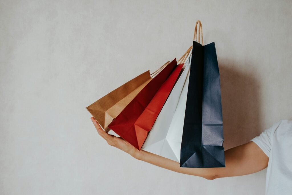 Mano sujetando bolsas de compra de colores: ventas rentables con Google Ads