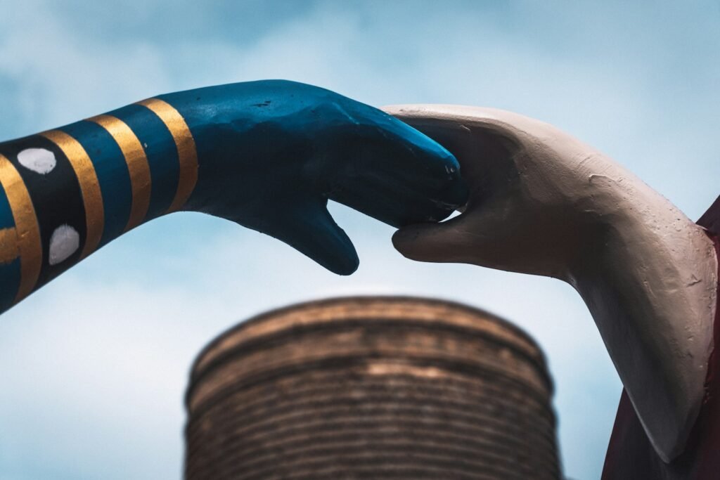 Dos manos que se acercan bajo el cielo, la conexión entre personas y agentes de inteligencia artificial