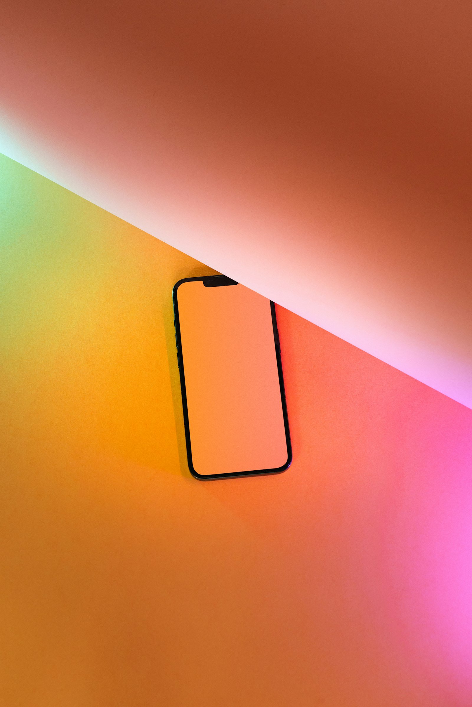 Smartphone sobre un fondo de colores naranja y rosa